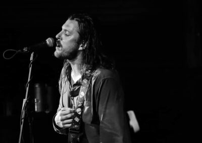 Black and white photo of zed charles singing into a microphone